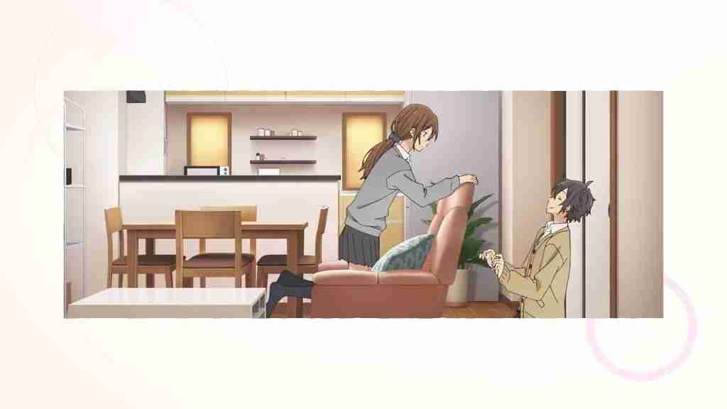 Miyamura-kun backs away with unease on the floor as Hori-san kneels looking over the back of the sofa at him