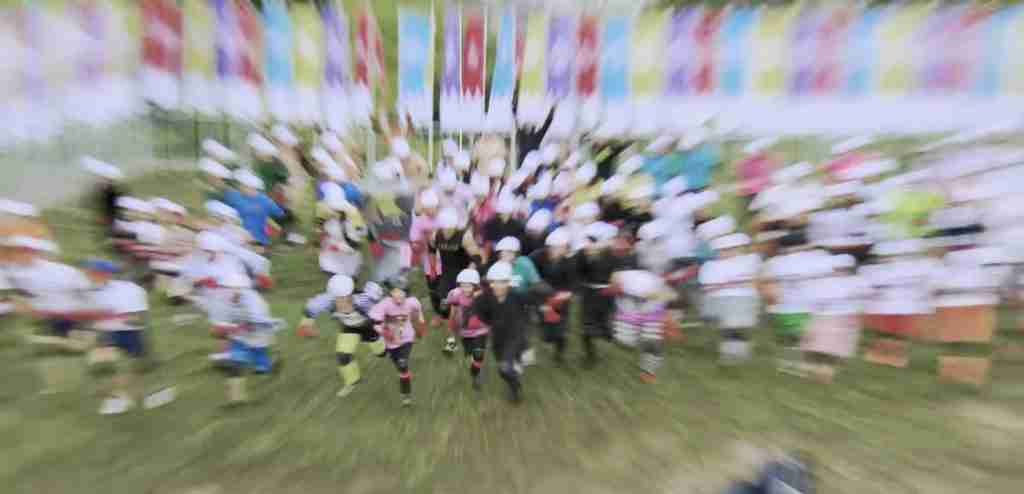 100 competitors charge across a field, motion blur for dramatic effect