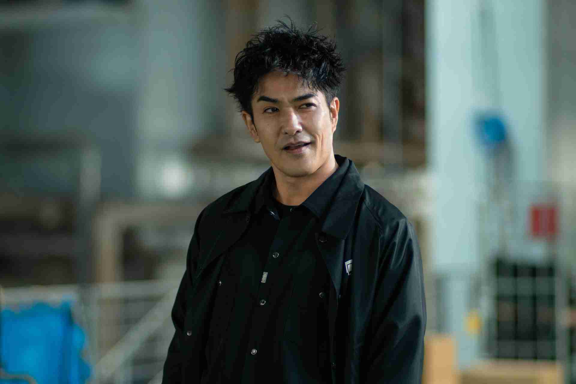 Kosugi (Kazuki Kitamura) looks off screen with a look of smarm on his face