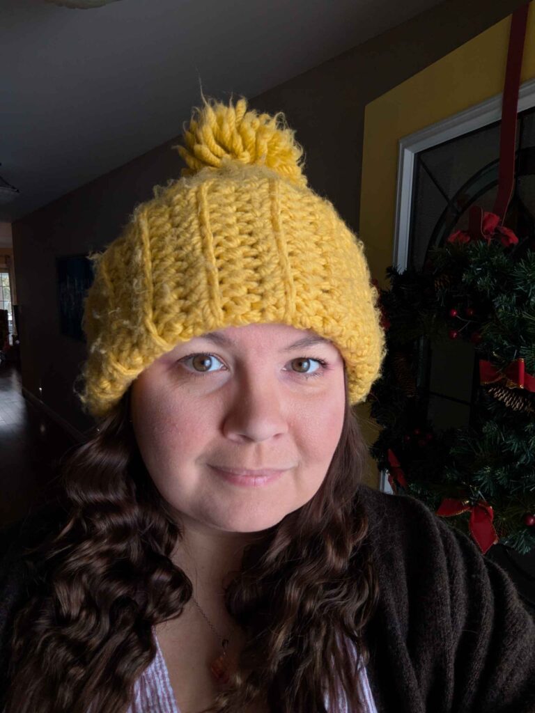 Author Mandy S Knight with a yellow knitted hat and brown curly hair