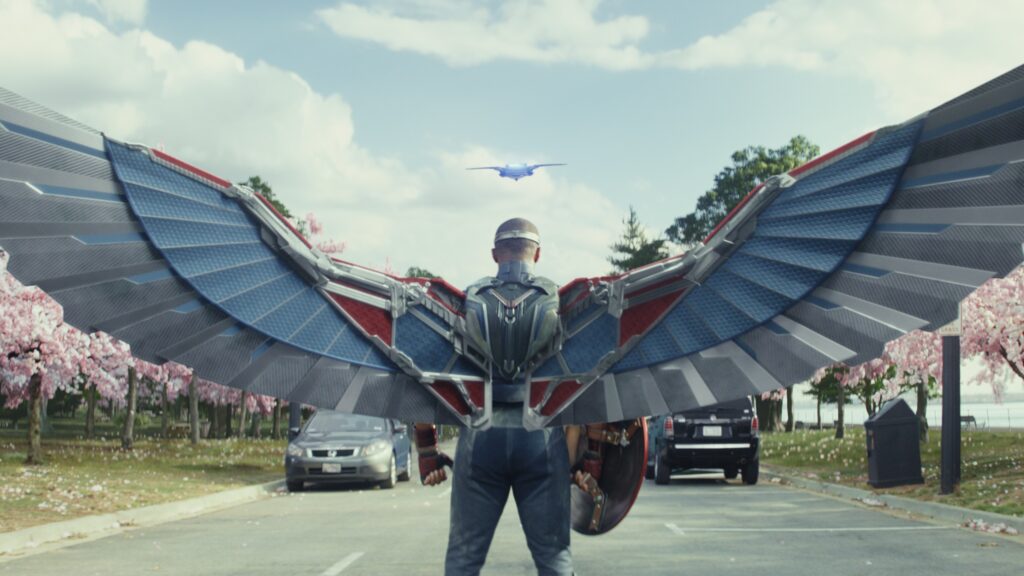 Sam Wilson, Captain America spreads his mechanical red, white and blue wings. Viewed from behind -  Captain America Brave New World 