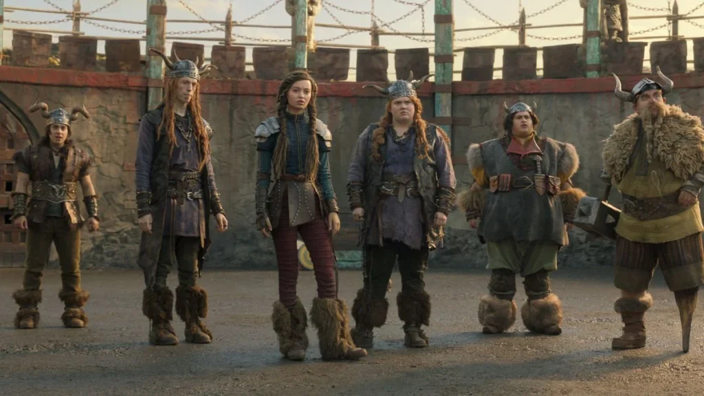 From left to right: 
Snotlout played by Gabriel Howell
Tuffnut played by Harry Trevaldwyn
Astrid played by Nico Parker
Ruffnut played by Bronwyn James
Fishlegs played by Julian Dennison
Gobber played bny Nick Frost - How to Train Your Dragon