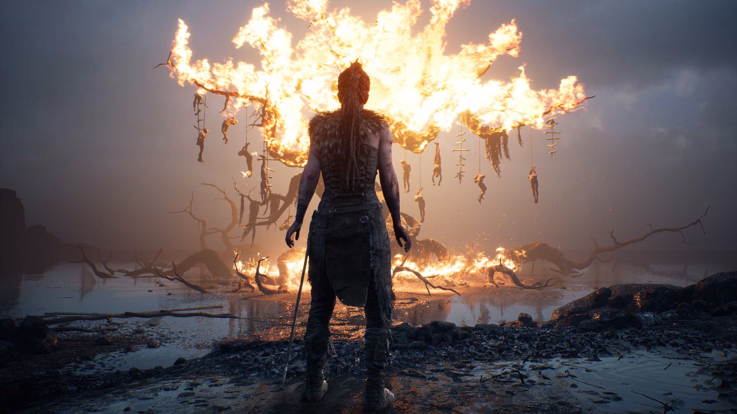 Senua stands before a burning tree - Hellblade: Senua’s Sacrifice