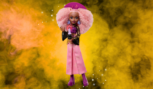 Monster High - a dark skinned witch with pink ofro carribbean hair. She is holding a candle and has a pink sarong type skirt on. 