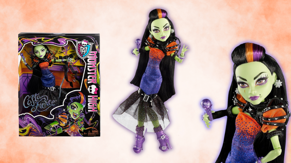 Casta Fierce monster high doll shown inside and out of her box. She is a witch type charcter with long black hair, a purple and orange dress and green skin.
