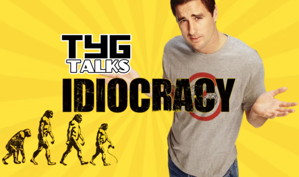 Yellow background with sun rays, a man to the right with a quizzical expression, arms raised outwards to his side, wearing a grey t-shirt with a red circle, the evolution of man in the bottom left corner, the name Idiocracy in the centre and TYG Talks logo just above the title to its right.